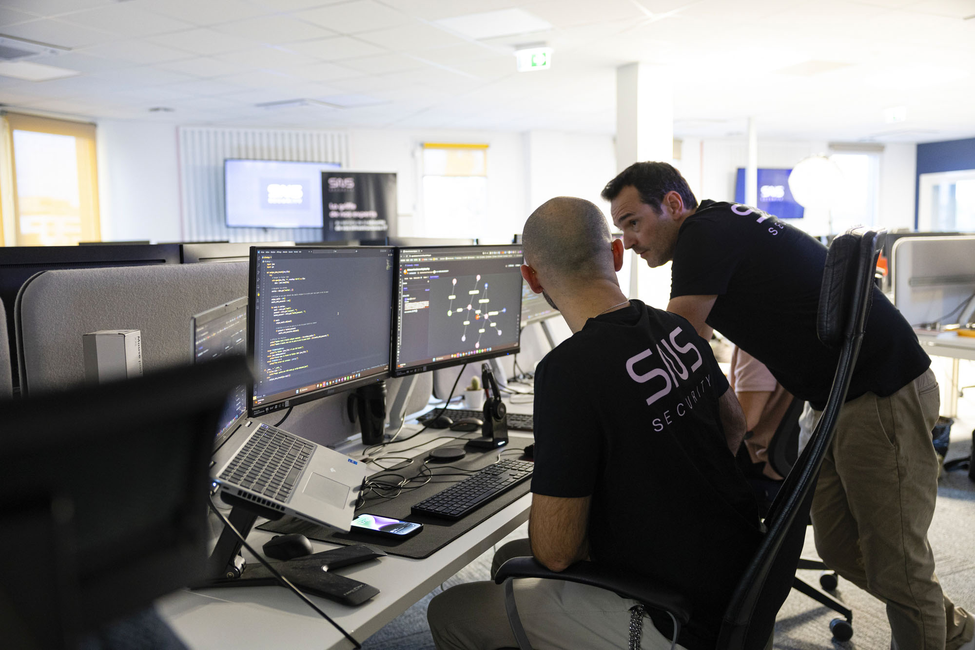 deux analystes SOC SNS Security qui discutent dans l'open space