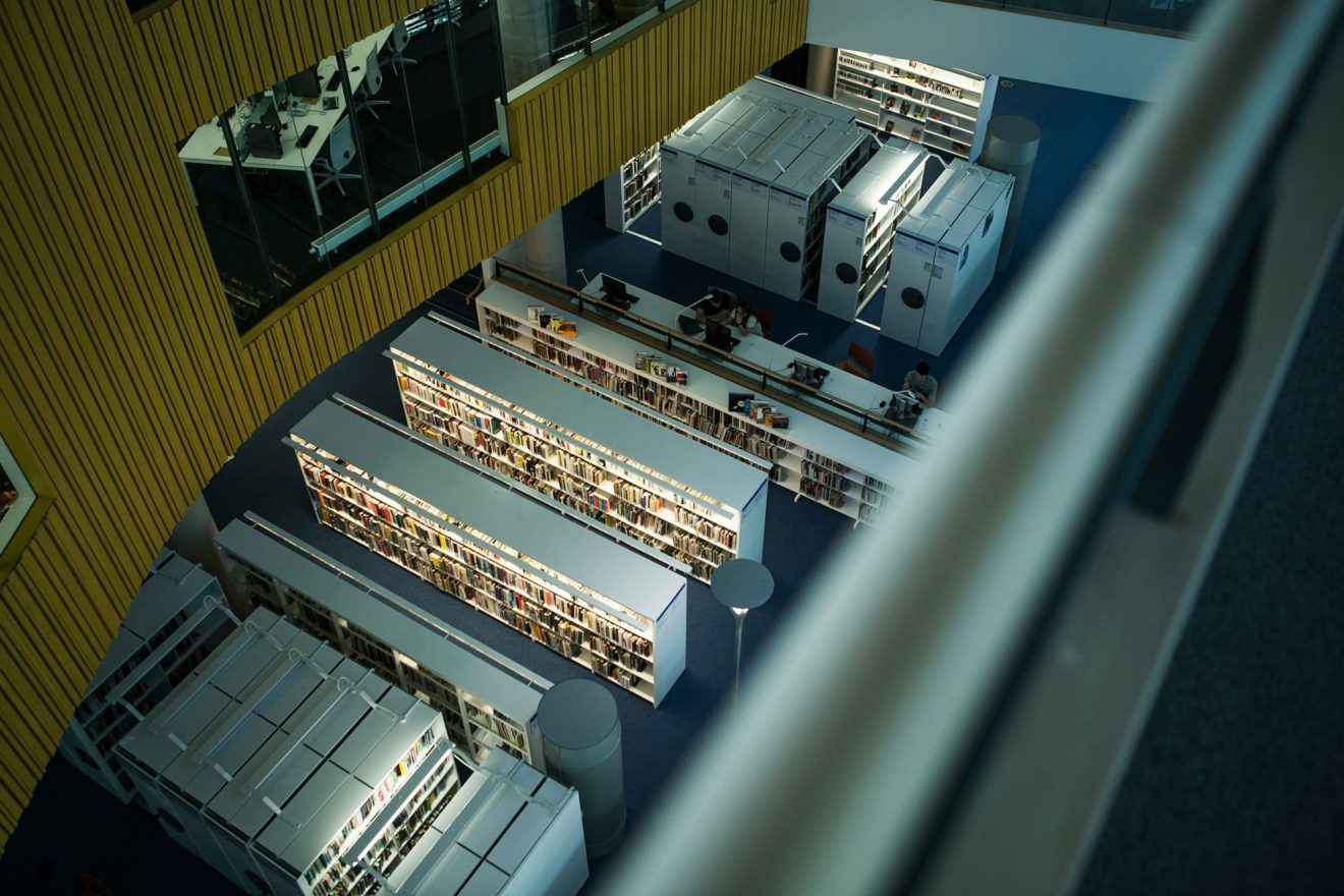 dans une bibilothèque vue plongeante sur des armoires de livres