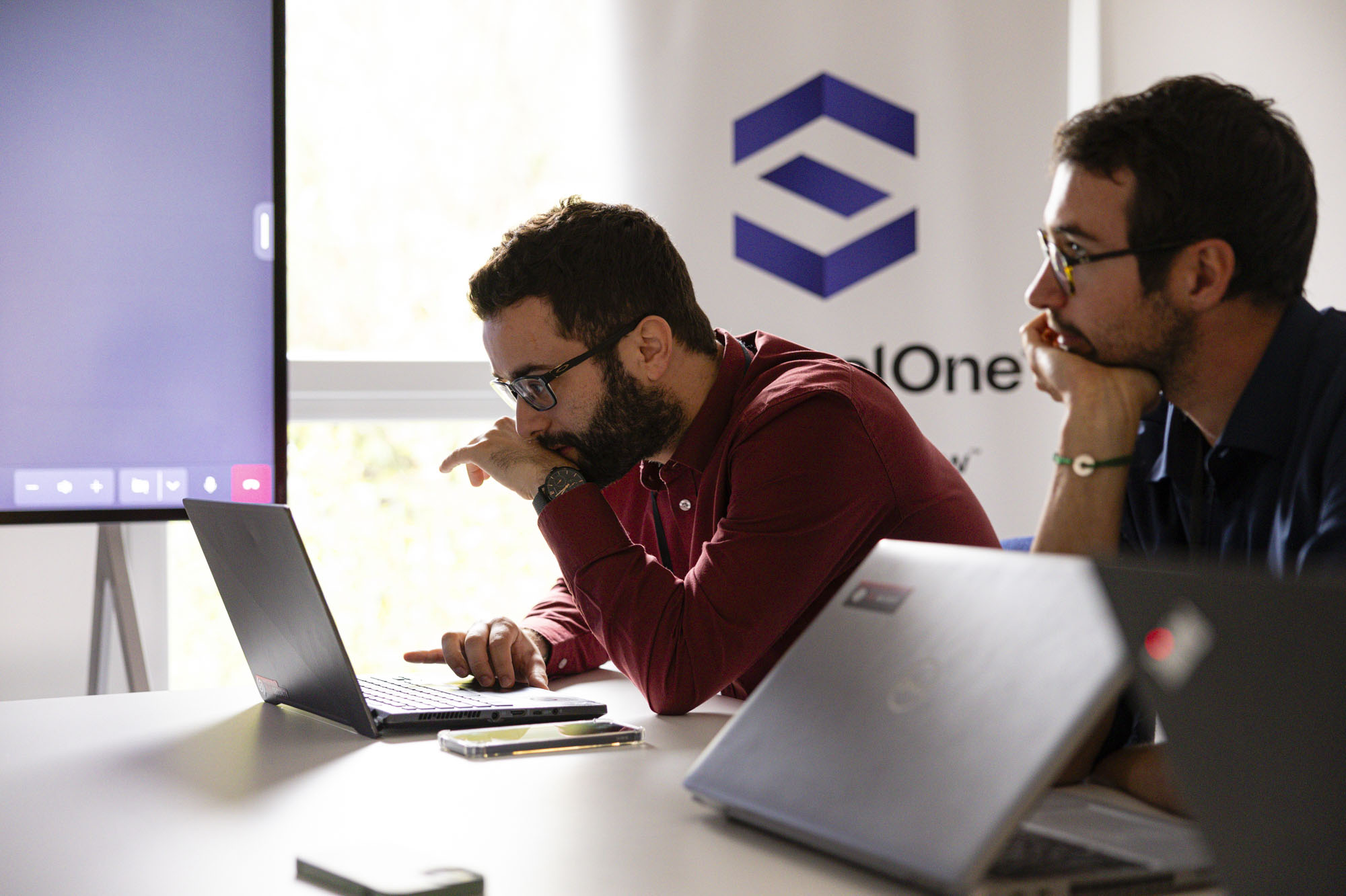 deux collaborateurs sont en réunion devant leurs ordinateurs portables